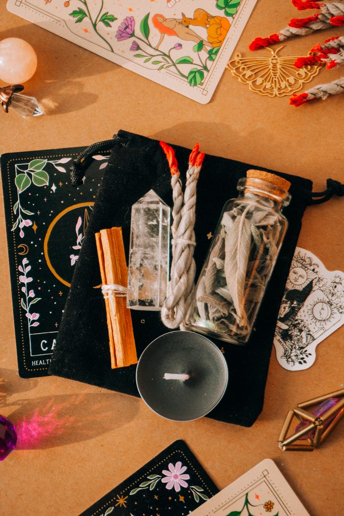 A mystical setup with tarot cards, crystals, sage, and candle for a spiritual ritual.